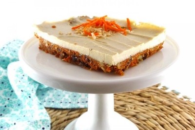 A slab of carrot cake sits on top of a cake stand.
