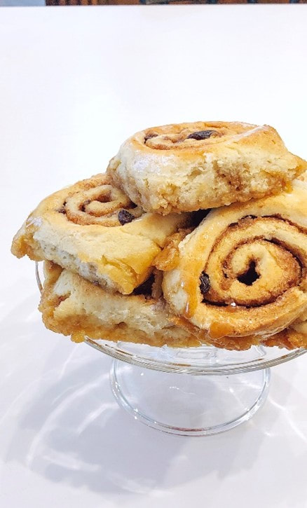 A stack of Cinnamon Swirl pastries on a glass cake stand.