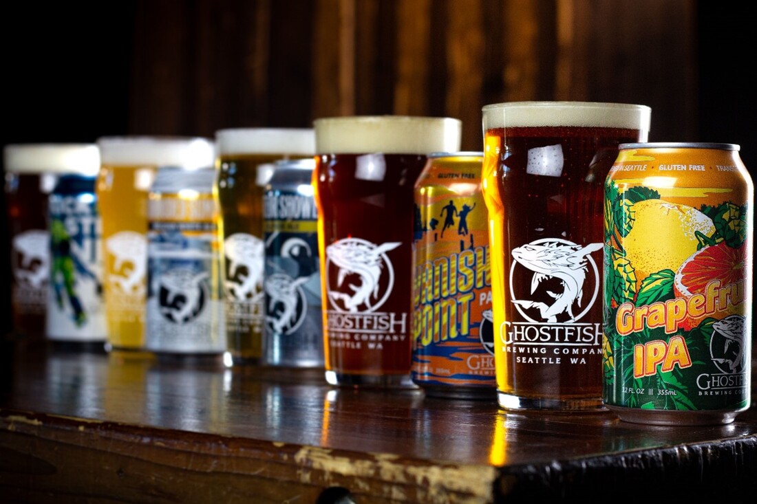 9 Ghostfish beers are lined up in a row on a bar table.